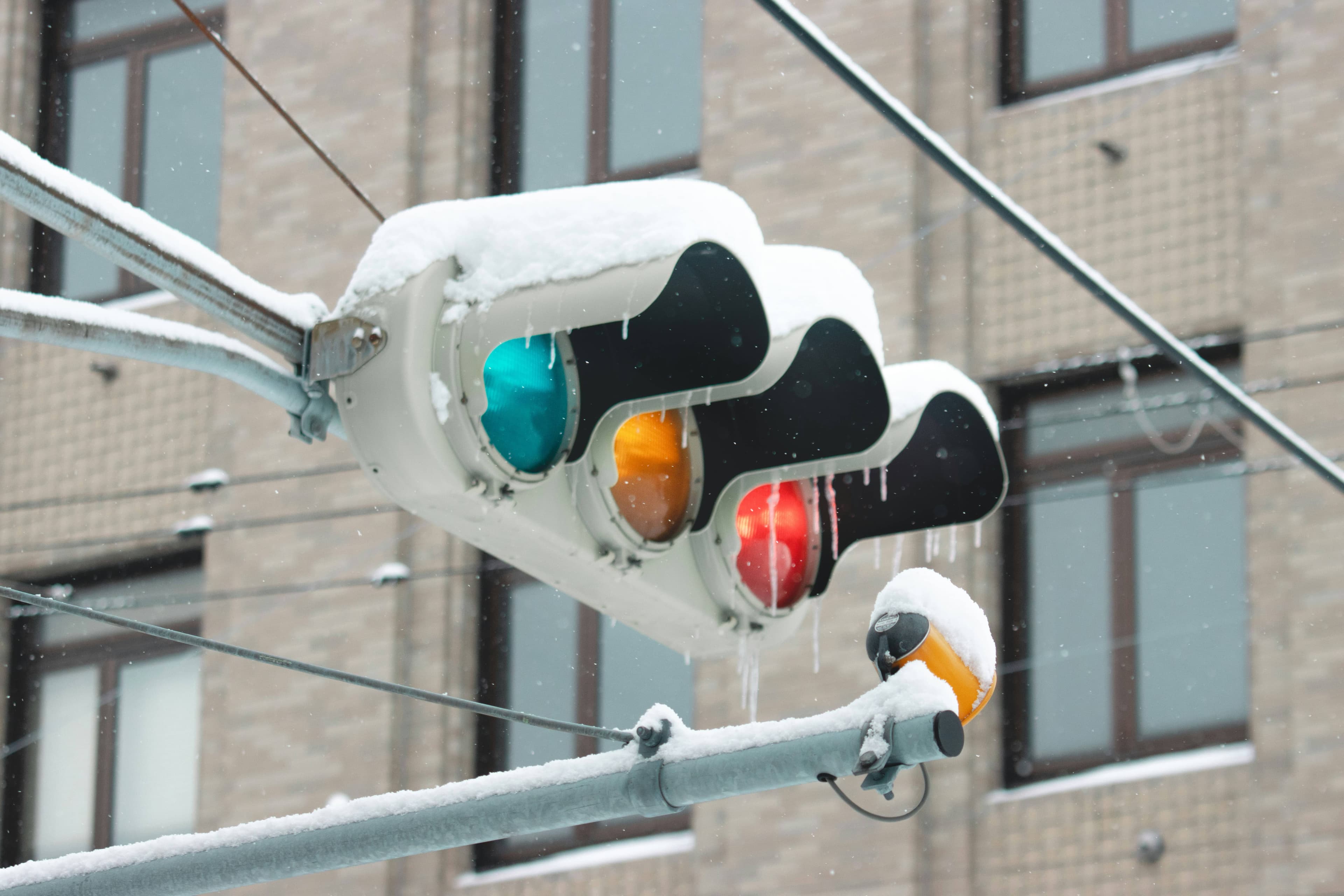 A traffic light, covered in recent snowfall.
